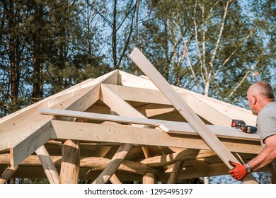 Carpenter Working On A Roof Of A Wooden Garden Bower