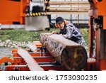 Carpenter working on a sawmill on a wood manufacture