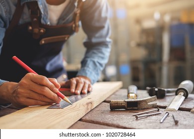 Tischler, die an Holzbearbeitungsmaschinen in der Tischlerei arbeiten. Frau arbeitet in einer Tischlerei.