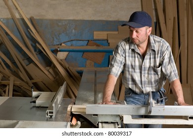 Carpenter working on woodworking machines in carpentry shop.