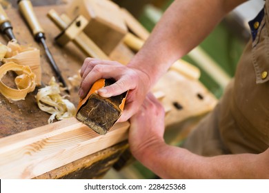 Carpenter working with a sanding block and sandpaper in his workshop