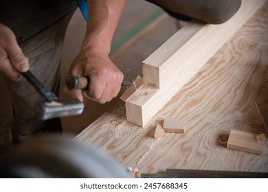 Carpenter working with wood using a chisel