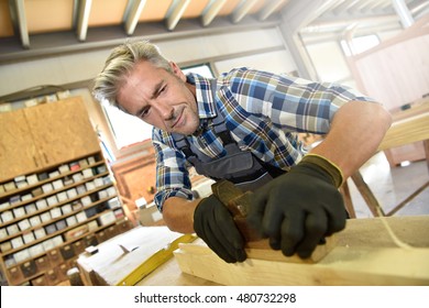 Carpenter Working Wood In Workshop