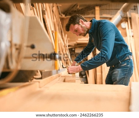 Carpenter Working In Woodwork Workshop Measuring Wood For Project