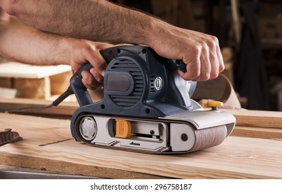 carpenter works with belt sander in carpentry - Powered by Shutterstock