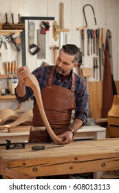 Carpenter Works With A Planer In A Workshop For The Production Of Vintage Furniture. He Makes Cabriole Leg For A Table In The Style Of Louis And Queen Anne/Joiner Makes Cabriole Leg For Vintage Table