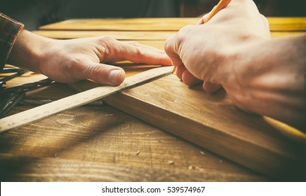 The carpenter works with wood on his workspace