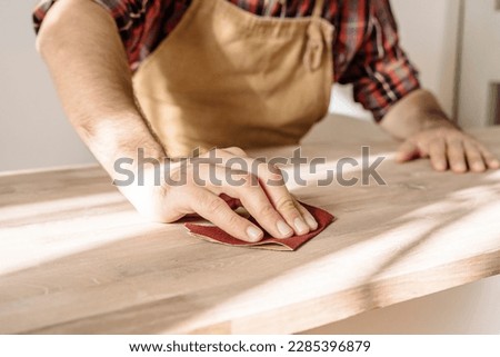 Carpenter works with wood in the workshop. Small business, production, craft concept.