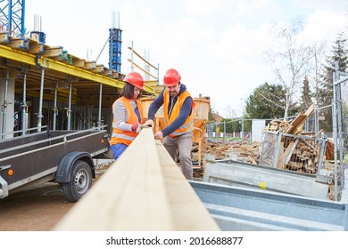 Carpenters Craftsmen Team Controls Lumber Delivery In Front Of The Construction Site Of House Building