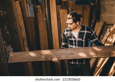 The carpenters man high experienced wood worker making furniture. Master of woodcraft male looking at wood panel.