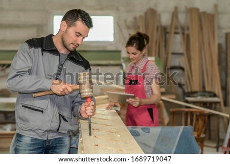 Carpenters is mortising a piece of wood for a stair