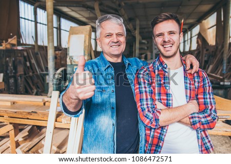 Carpenters standing proud in front of a workshop, family business