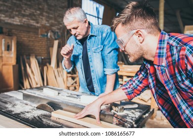 Carpenters using circular saw in workshop