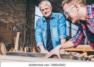 Carpenters using circular saw in workshop