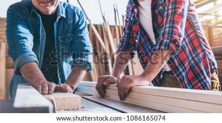 Carpenters using circular saw in workshop