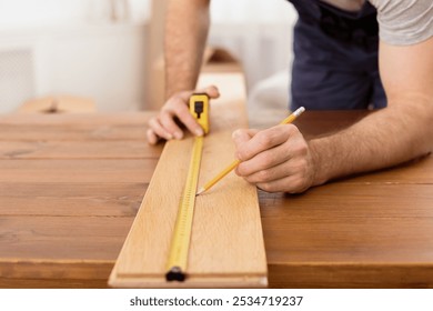 Carpentry Career Concept. Unrecognizable Carpenter Measuring Wooden Board Making A Piece Of Furniture Working In His Studio. Cropped Shot, Selective Focus - Powered by Shutterstock