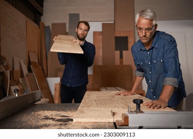 Carpentry, carpenter and men in workshop work on design project with team, vocation and creative DIY skill. Teamwork, collaboration and male employee saw wood with father and son working together - Powered by Shutterstock