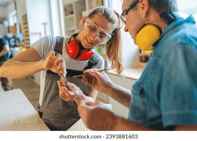 Carpentry mentor and apprentice measuring a wooden piece in a well-lit workshop - Powered by Shutterstock