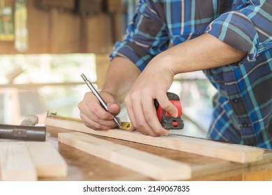 Carpentry Professional, Hand Of Asian Young Man, Male Carpenter Use Tape Measure, Tool On Board Wood In Small Shop. Woodwork, Furniture Making, Construction Industry. Owner Small Business People.