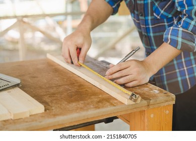 Carpentry Professional, Hand Of Asian Young Man, Male Carpenter Use Tape Measure, Tool On Board Wood In Small Shop. Woodwork, Furniture Making, Construction Industry. Owner Small Business People.