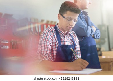 Carpentry student taking notes in workshop