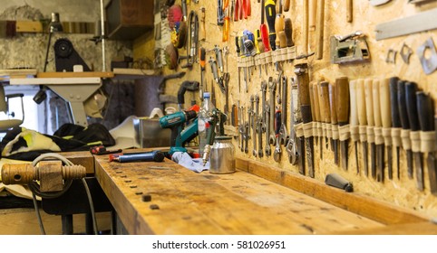 carpentry, woodwork and equipment concept - work tools and workbench at workshop