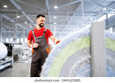 Carpet factory. Worker standing by machine and checking carpet production inside textile factory. - Powered by Shutterstock