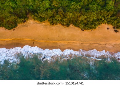 carpet of sea waves covering the orange sands of a secluded beach in Goa