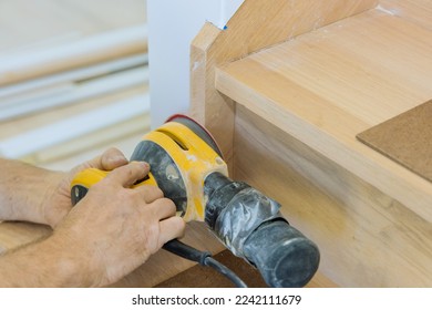 Carpeter grinding using polishing machine refinishing stairwell of railing in new home