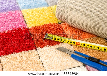 Carpeting colorful swatches, boxcutter and tape measure