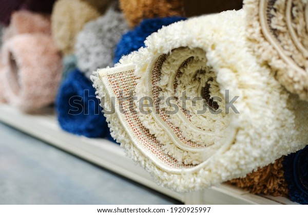 Carpets with large pile, rolled into a roll, lie
on the counter in the store. Wholesale retail trade in floor
coverings. Close-up