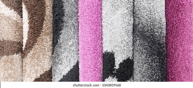 Several Rolled Up Rugs In Different Sizes Patterns Colors And Textures Leaning Up Against A White Paneled Wall Rugs Crate And Barrel Modern Rugs