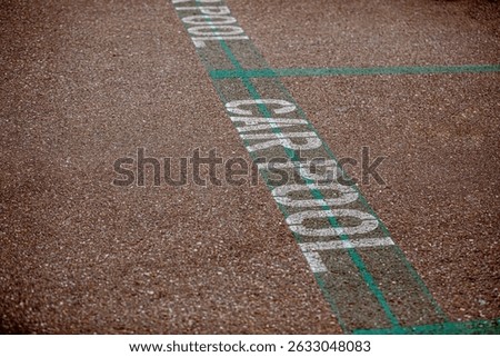 Carpool parking symbol painted on asphalt parking lot surface informing that this parking spot is reserved for car sharing drivers. Parking space for carpooling drivers