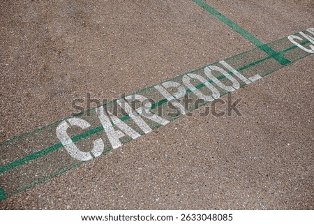 Carpool parking symbol painted on asphalt parking lot surface informing that this parking spot is reserved for car sharing drivers. Parking space for carpooling drivers