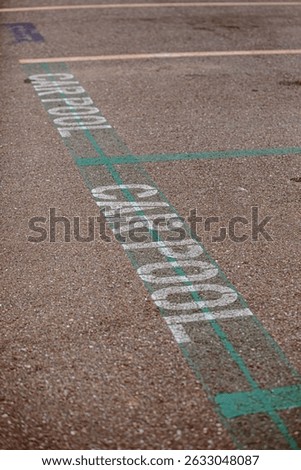 Carpool parking symbol painted on asphalt parking lot surface informing that this parking spot is reserved for car sharing drivers. Parking space for carpooling drivers