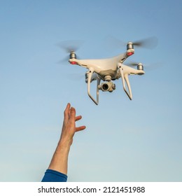 Carr, CO, USA - April 12, 2017:  Launching or catching  DJI Phantom 4 pro quadcopter drone - operator hand and drone against sky.