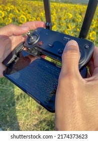 Carreco, Portugal, August 1, 2021: Man Piloting A Drone In The Air With A Remote Controller In His Hands-on Sunset. The Pilot Takes Aerial Photos And Videos With Quadcopter From Above.