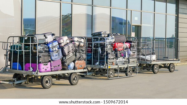 Carriage of a lot of luggage of passengers at the\
airport. airport luggage\
car