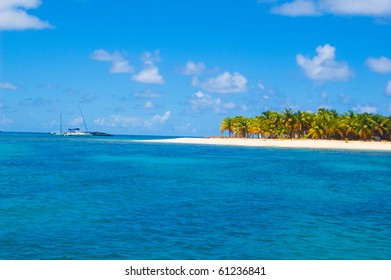 Carribean Island With Sailboat In Blue Ocean