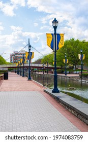 Carroll Creek Park in the heart of downtown Frederick, Maryland with a paved walk along the creek and flags on the lightposts