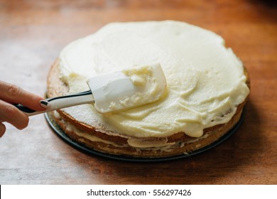 A Carrot Cake Being Spread With Cream Cheese Creme