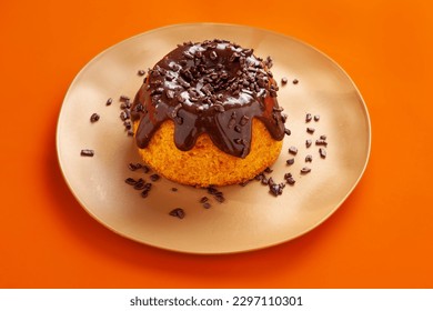 Carrot cake on orange background.  Mini volcano cake with chocolate topping and chocolate sprinkles isolated on orange background