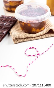 Carrot And Chocolate Jar Cake Minimalist Composition With Chocolate Bar, Kitchen Cloth Cup Of Coffee And Baker Twine String. Food Concept.