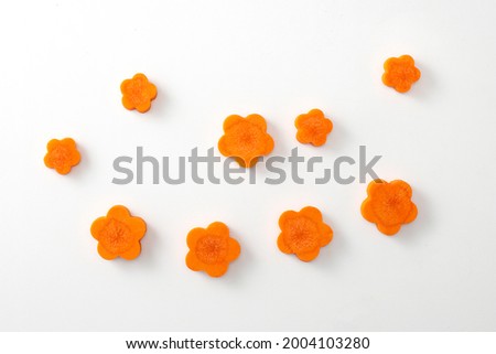 Carrot flower sliced cut on white background. Close up vegan food flat lay top angle view carrots in flower shape