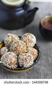 Carrot halva balls in coconut chips, traditional Indian sweet, selective focus on a central ball