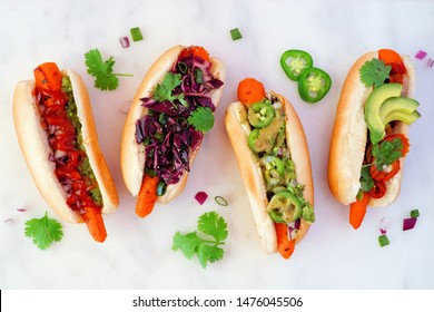 Carrot hot dogs with assorted toppings. Top view on a white marble background. Plant based meatless meal concept. - Powered by Shutterstock