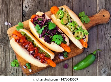 Carrot hot dogs with assorted toppings. Top view on paddle board with a rustic wood background. Plant based vegan meal concept. - Powered by Shutterstock