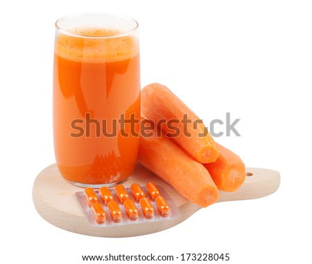 carrot juice, fresh carrots and beta Carotene capsules on cutting board