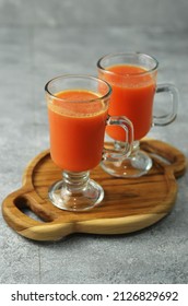 Carrot juice is a healthy drink made from a mixture of various fruits and vegetables, carrots, apples, and tomatoes. Served in a glass on the table. Selective focus