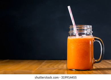 Carrot Juice In Masons Jar On Black Background